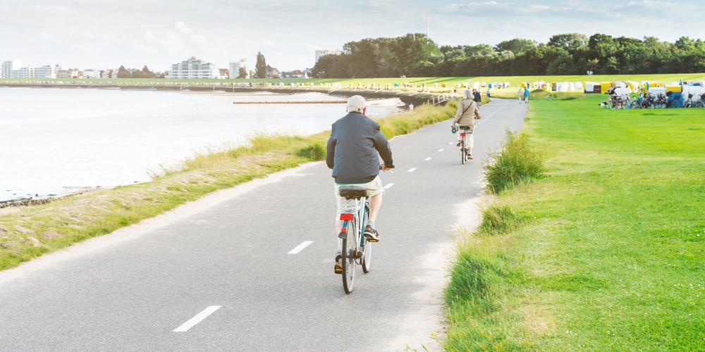 Menschen fahren mit dem Fahrrad am Ufer in Cuxhaven
