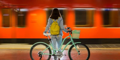Das 1 Euro Fahrradticket in Bayern. Frau sitzt auf Ihrem Fahrrad und wartet auf die Bahn.