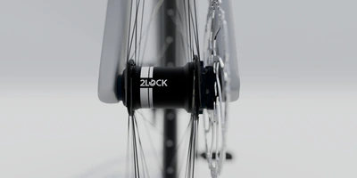 Nahaufnahme eines Fahrradnabe mit Speichen auf hellgrauem Hintergrund.