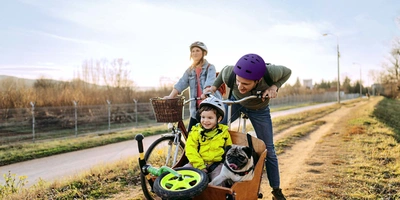 linexo Services Fröhliche Familienradtour mit Fahrrad und Lastenrad mit Kind und Hund im Anhänger