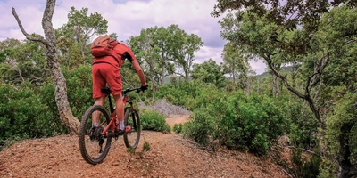 Mann fährt mit einem E-Mountainbike durch die Natur