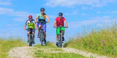 Drei E-Bike Fahrer, fahren auf einem Gelände