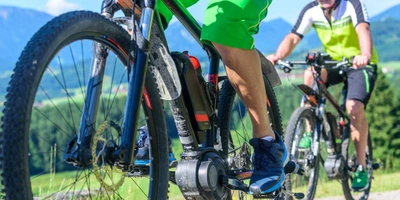 Zwei E-Bike Fahrer fahren einen Berg hoch