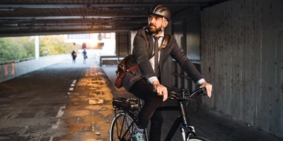 Mann in Business-Klamotten fährt mit einem E-Bike durch einen Tunnel.