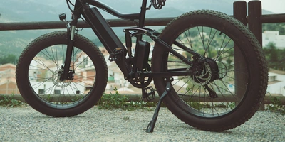 Fahrradständer als langweiliger aber notwendiger Teil eines Fahrrads Ein E-Bike steht auf einer Schotterstraße