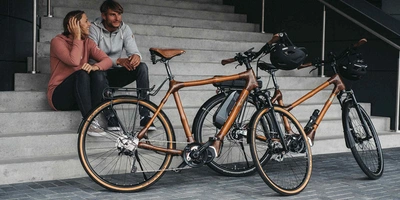 Bambus E-Bikes für ein reines Gewissen Zwei Personen sitzen neben Bambus-E-Bikes