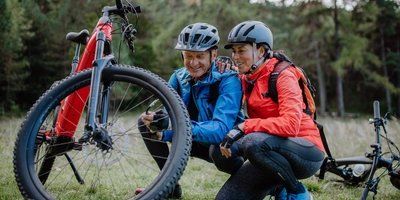 Ein Mann und eine Frau betrachten ihren E-Bike Reifen Ein Mann und eine Frauen betrachten ihren E-Bike Reifen