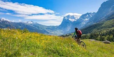 Frau fährt mit einem E-Mountainbike durch die Schweizer Alpen