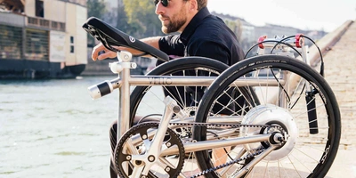 Mann sitzt neben Klapprad