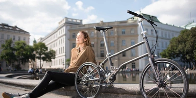 Frau sitzt neben Fahrrad