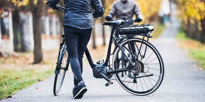 Personen mit E-Bikes in einem Park