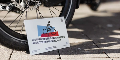 Schild mit Aufschrift "Fahrradfreundlichster Arbeitgeber" steht vor Fahrrad