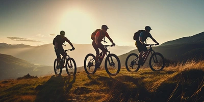 3 Mountainbiker fahren im Sonnenuntergang Berg hoch
