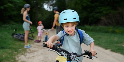 Kind fährt durch Bild und Familie im Hintergrund