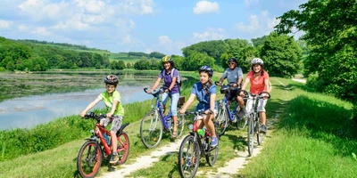 Familie fährt mit Kinder neben See
