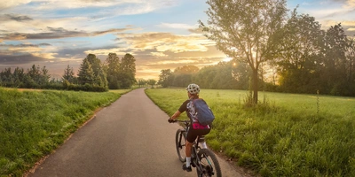 Entdecke die schönsten Radwege in Baden Württemberg Frau fährt mit einem E-Bike auf einem Radweg durch die Natur in Baden-Württemberg