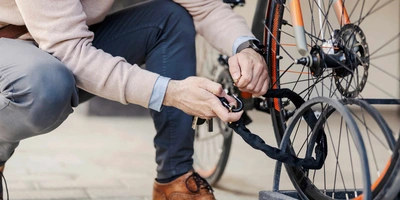 Person schließt ein Fahrrad ab