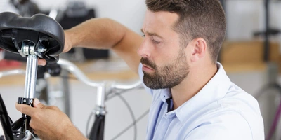 So funktioniert professionelles Bikefitting Mann stellt Sattel von Fahrrad ein