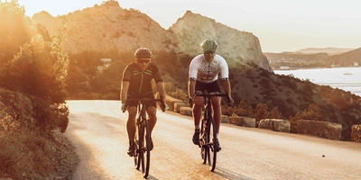 Das Blade One ist ein City-E-Bike mit Rennrad-Charakter. zwei Männer fahren auf Rennrädern an Küste entlang.