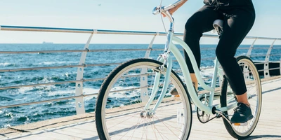 Frau auf Fahrrad in Vintage Optik am Meer