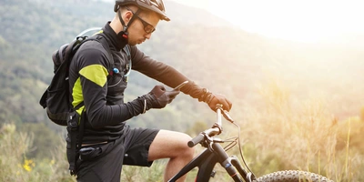 Bosch Fahrrad System mit App-Unterstützung Mann auf E-Bike nutzt ein Smartphone