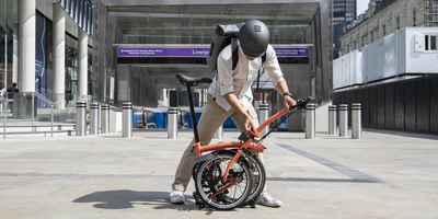 Das Brompton Faltrad – schnell, mobil und komfortable Person faltet das Brompton Faltrad