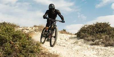 Man fährt eine Downhill-Strecke mit einem E-Bike Fully herunter.
