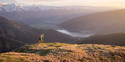 Mountainbiker fährt in den Bergen im Sonnenuntergang.