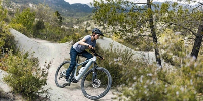 Canyon hat weltweiten einen sehr guten Ruf in der Bike-Szene. Frau fährt mit Mountainbike über Gravelpiste.