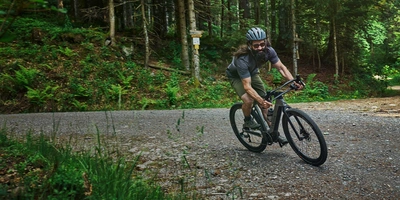 So sieht das neue Canyon E-Gravel aus. Mann fährt auf Canyon E-Gravel durch Wald.
