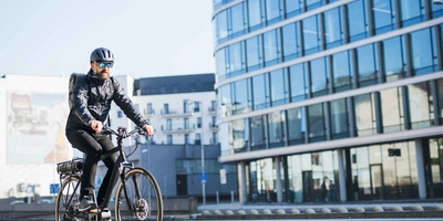 Mann mit Helm fährt auf E-Bike.