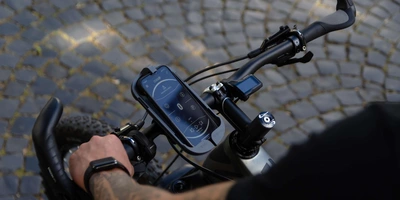 Smartphone befindet sich in einer Halterung am Fahrrad.