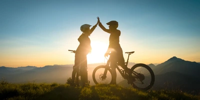zwei Fahrradfahrer in den Bergen geben High-Five