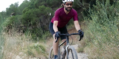 Mann fährt auf Crossbike durch Steppe.
