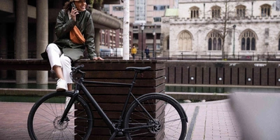 Decathlon erweitert sein Sortiment an E-Bikes Frau posiert neben Fahrrad