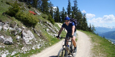 Ein Mann fährt mit dem Fahrrad einen Weg runter