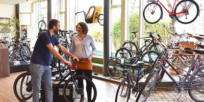 Zwei Personen unterhalten sich im Fahrradhandel.