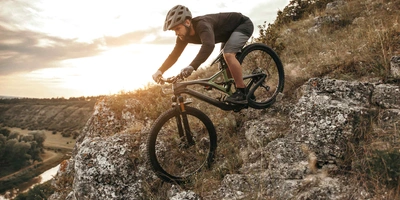 Mann fährt Mountainbike steilen Berg hinunter.