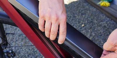 E-Bike Akku richtig laden - darauf solltest du achten Person setzt den Akku eines E-Bikes ein