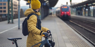 Ein Mann wartet mit seinem Fahrrad auf dem Zug