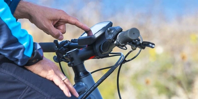 Ein Mann tippt auf dem Touch-Display seines Fahrrad-Computers.