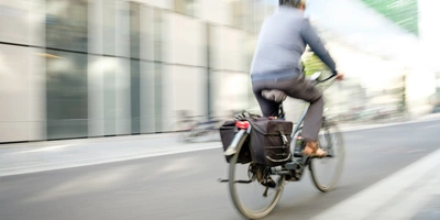 E-Bike-Abo als Alternative zur klassischen Gehaltserhöhung E-Bike-Fahrer fährt durch eine Stadt