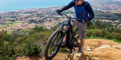 Mann fährt mit einem E-Mountainbike über einen Trail 