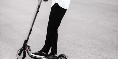 Person steht auf einem E-Scooter