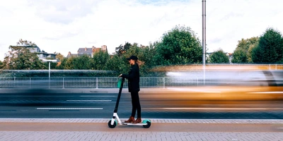 Potenzial der Mobilitätswende E-Scooter Frau auf E-Scooter fährt an viel befahrender Straße