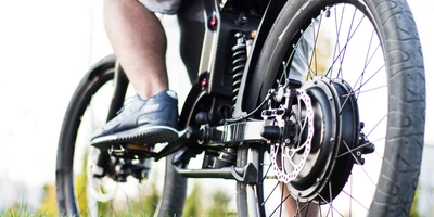 Diese E-Bike Motoren gibt es 2024 auf dem Markt. Nahabbildung von Kette und Motor eines E-Bikes.