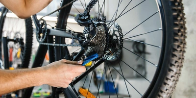 Das sind die Vorteile und Kosten einer E-Bike Automatikschaltung. Mann tauscht Kette an Fahrrad aus.