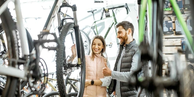 Mann und Frauen stehen vor E-Mountainbike und beraten sich.