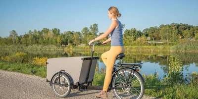 Frau fährt auf einem Lastenrad.