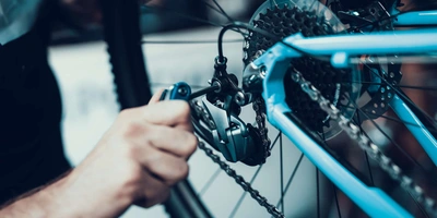 Fahrradschaltung Person berührt die Fahrradschaltung eines blauen Fahrrads